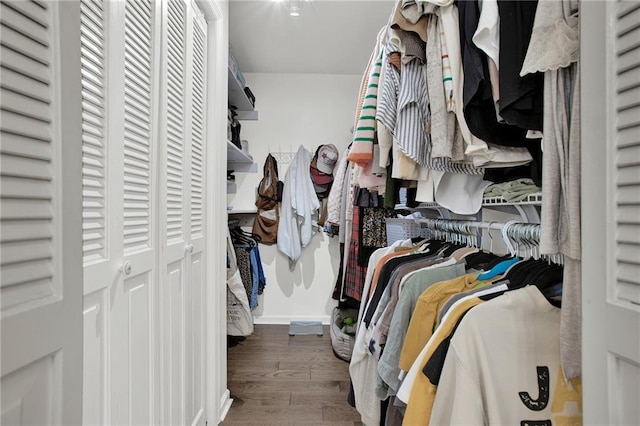 walk in closet with dark hardwood / wood-style floors