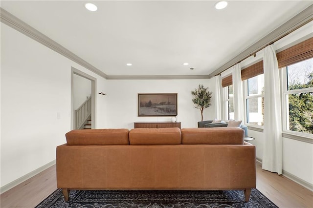 living room with ornamental molding and light hardwood / wood-style floors