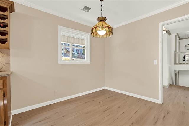 unfurnished dining area with light wood-type flooring and ornamental molding