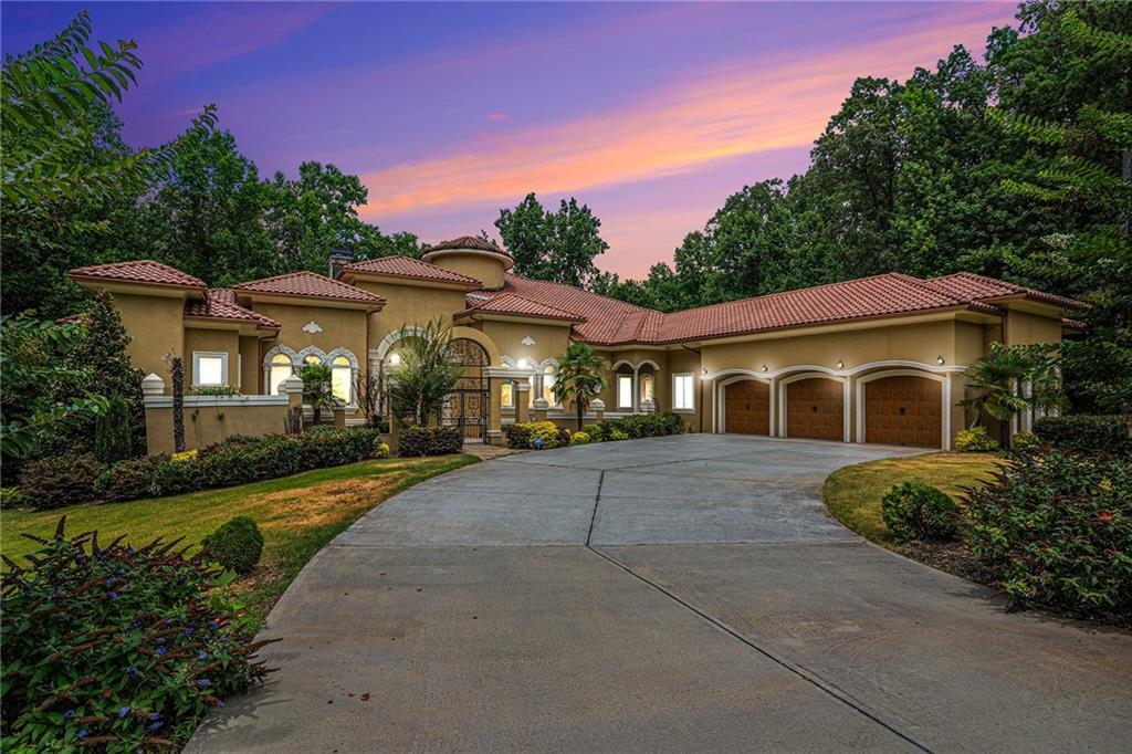 mediterranean / spanish-style home featuring a garage and a yard