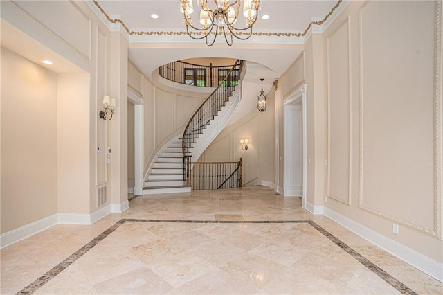 entryway with crown molding and a chandelier