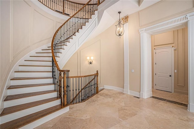 stairs with a notable chandelier