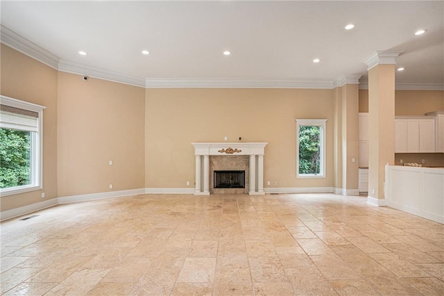 unfurnished living room with a high end fireplace, ornamental molding, and a healthy amount of sunlight