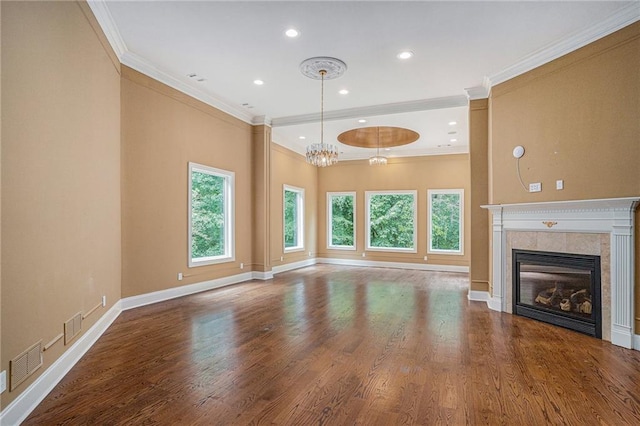 unfurnished living room with wood-type flooring, a fireplace, a chandelier, and crown molding