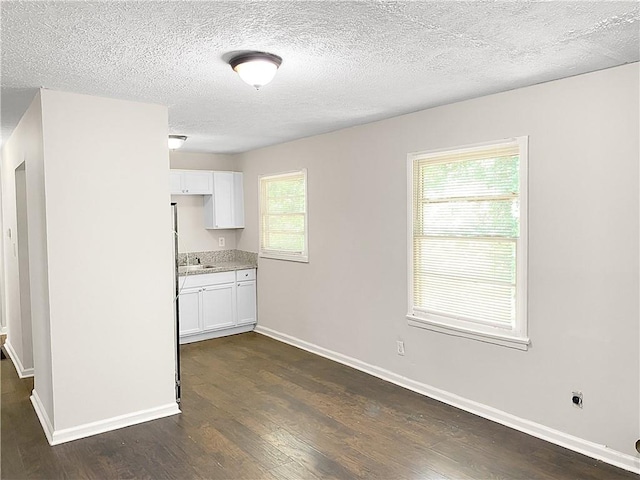 kitchen with dark wood-type flooring, sink, a textured ceiling, and white cabinets