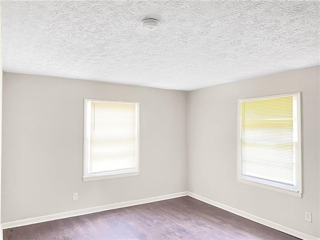 unfurnished room with dark hardwood / wood-style floors and a textured ceiling