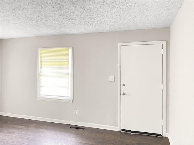 entrance foyer with dark hardwood / wood-style flooring and a textured ceiling