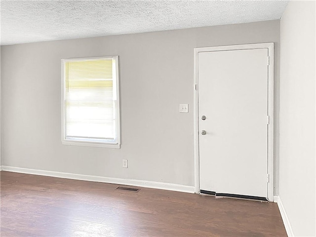 foyer with a textured ceiling and dark hardwood / wood-style flooring