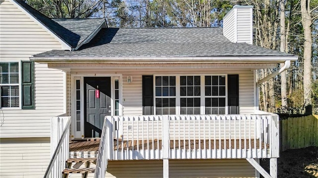 view of front of home with a shingled roof and a chimney