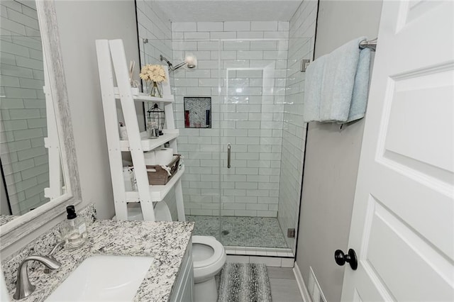 bathroom featuring an enclosed shower, vanity, and toilet