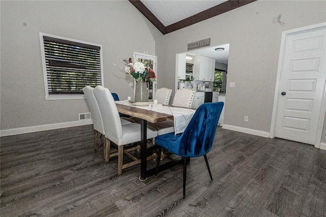 dining room with vaulted ceiling with beams and dark hardwood / wood-style flooring