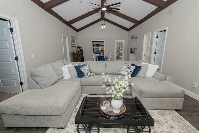 living room featuring dark wood-type flooring, high vaulted ceiling, beam ceiling, and ceiling fan