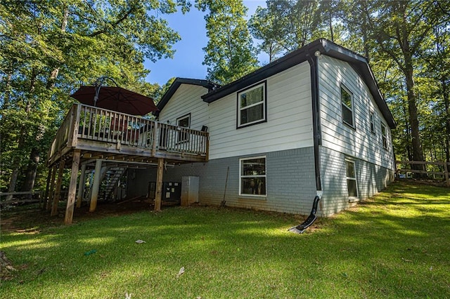 rear view of house featuring a yard and a wooden deck