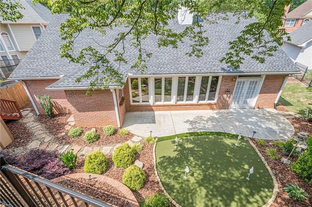 10280 Medridge Cir, Johns Creek, GA 30022 - rear view of property with roof with shingles, an area to practice putting, brick siding, and a patio
