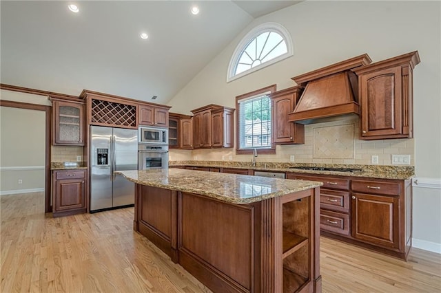 10280 Medridge Cir, Johns Creek, GA 30022 - kitchen featuring built in appliances, a kitchen island, high vaulted ceiling, tasteful backsplash, and light wood-style floors