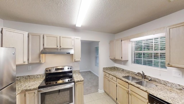 kitchen featuring appliances with stainless steel finishes, a sink, under cabinet range hood, a textured ceiling, and light tile patterned floors