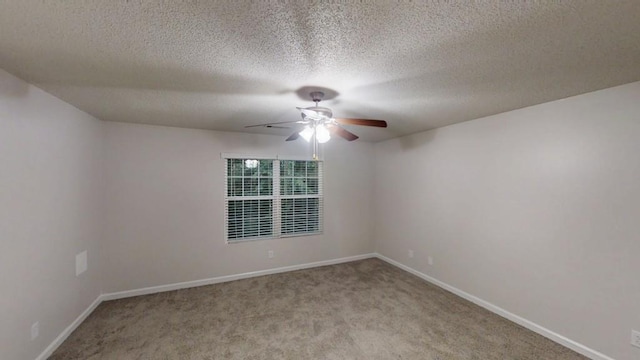 spare room with ceiling fan, light carpet, baseboards, and a textured ceiling