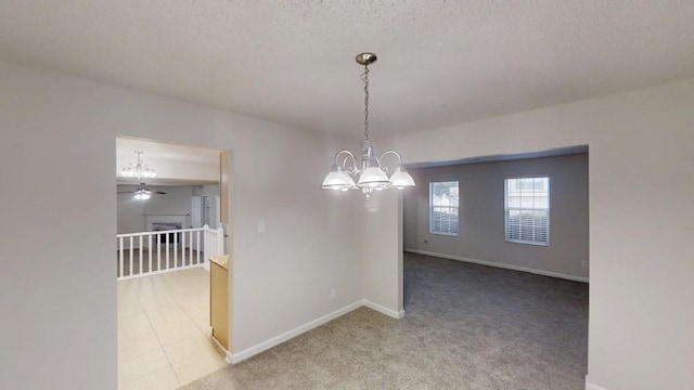 unfurnished room with a chandelier, baseboards, light carpet, and a ceiling fan