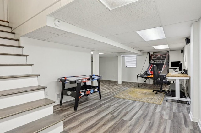 game room with wood-type flooring and a paneled ceiling