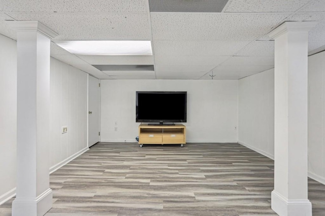 basement with wood-type flooring and a paneled ceiling