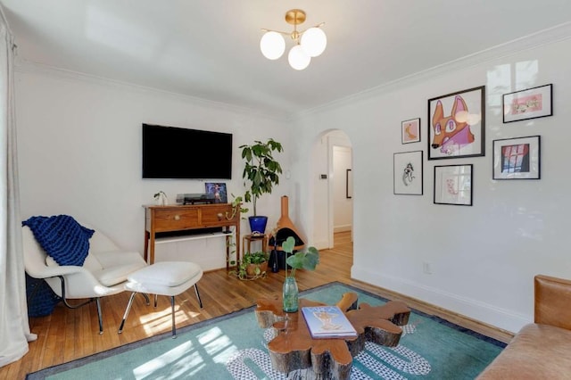 living room featuring a notable chandelier, crown molding, and wood-type flooring