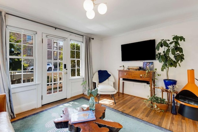 living room with crown molding, wood-type flooring, and a chandelier