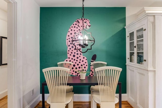 dining space featuring hardwood / wood-style floors and an inviting chandelier