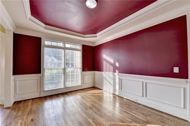 1755 Riverpark Dr, Dacula, GA 30019 - spare room featuring a raised ceiling, wainscoting, wood finished floors, and crown molding