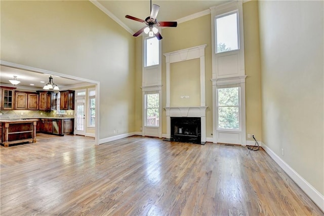 1755 Riverpark Dr, Dacula, GA 30019 - unfurnished living room featuring high vaulted ceiling, ornamental molding, healthy amount of natural light, a ceiling fan, and light wood-type flooring