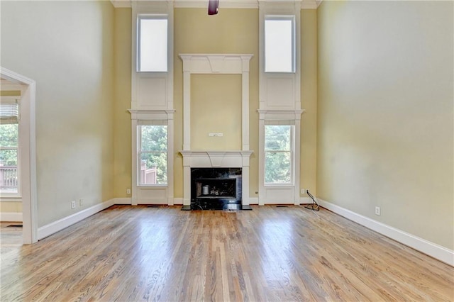 1755 Riverpark Dr, Dacula, GA 30019 - unfurnished living room featuring a fireplace, a towering ceiling, plenty of natural light, wood finished floors, and crown molding