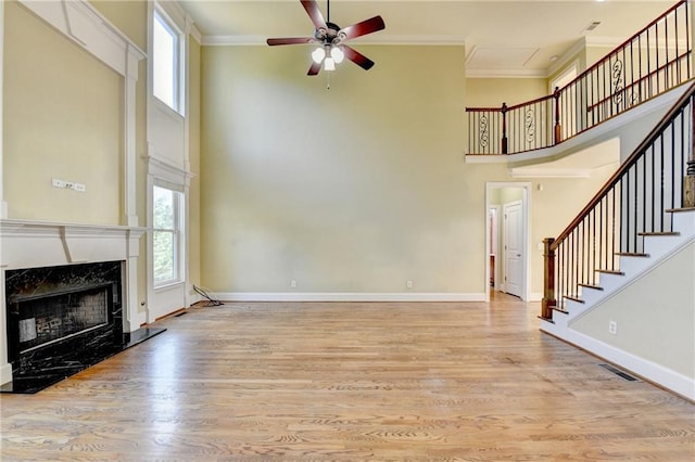 1755 Riverpark Dr, Dacula, GA 30019 - unfurnished living room with a towering ceiling, crown molding, ceiling fan, plenty of natural light, and wood finished floors