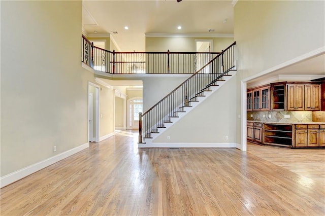 1755 Riverpark Dr, Dacula, GA 30019 - unfurnished living room with stairway, a high ceiling, light wood finished floors, ornamental molding, and recessed lighting