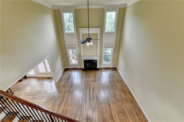 1755 Riverpark Dr, Dacula, GA 30019 - unfurnished living room with plenty of natural light, wood finished floors, a towering ceiling, a ceiling fan, and crown molding