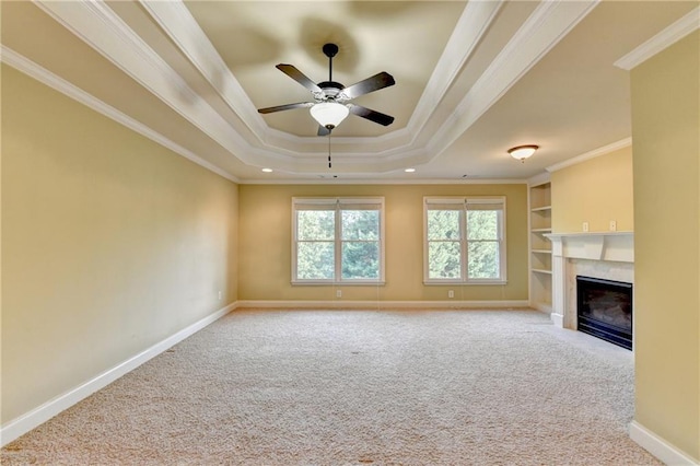 1755 Riverpark Dr, Dacula, GA 30019 - unfurnished living room with carpet flooring, a tray ceiling, a ceiling fan, a high end fireplace, and crown molding