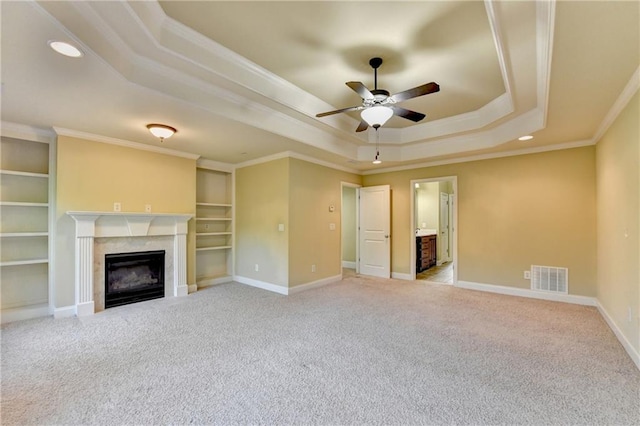 1755 Riverpark Dr, Dacula, GA 30019 - unfurnished living room featuring a tray ceiling, a high end fireplace, a ceiling fan, carpet floors, and ornamental molding