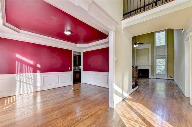 1755 Riverpark Dr, Dacula, GA 30019 - empty room with a fireplace, a ceiling fan, crown molding, wood finished floors, and a raised ceiling