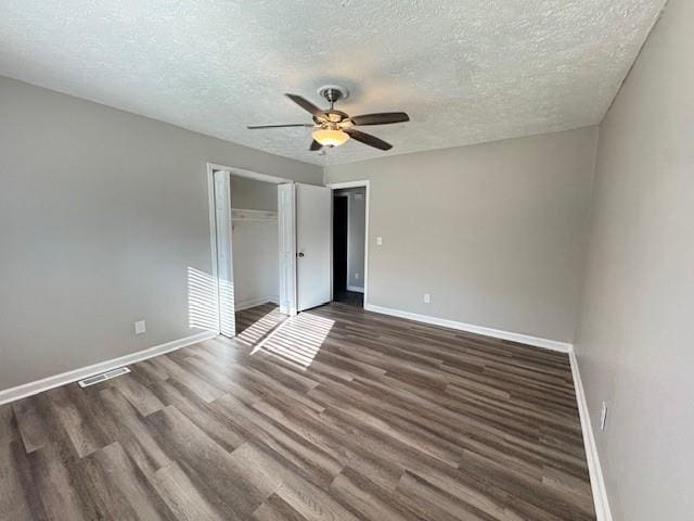 unfurnished bedroom featuring wood finished floors, visible vents, a closet, and baseboards