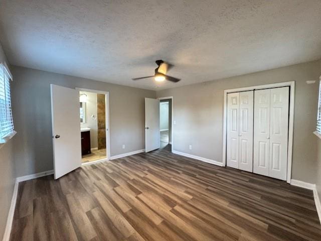 unfurnished bedroom with a closet, baseboards, dark wood-style floors, a textured ceiling, and ceiling fan