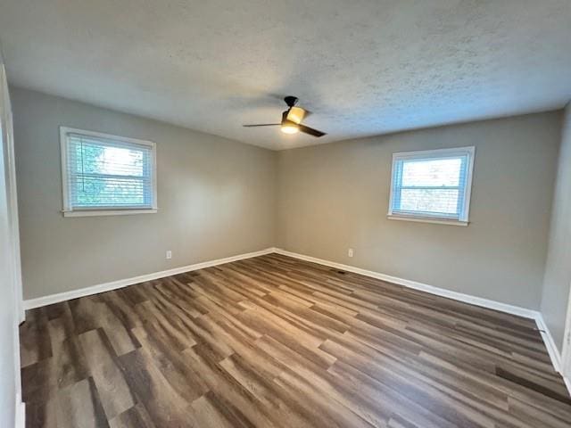 empty room featuring baseboards, a textured ceiling, dark wood finished floors, and a ceiling fan