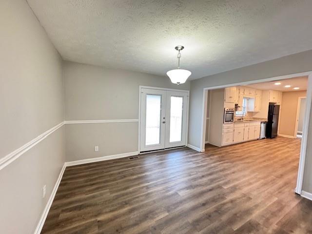 unfurnished dining area with dark wood-type flooring and baseboards