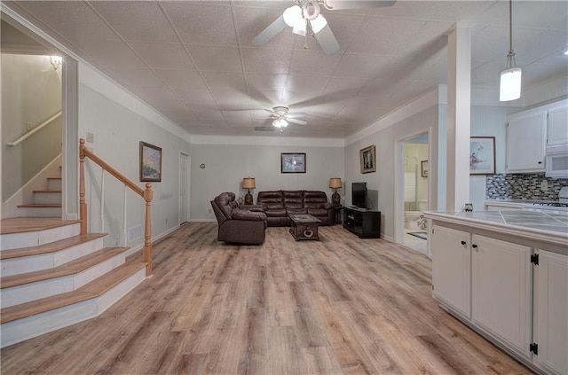354 Starcross Ln, Jasper, GA 30143 - living area featuring stairs, ornamental molding, ceiling fan, baseboards, and light wood-style floors