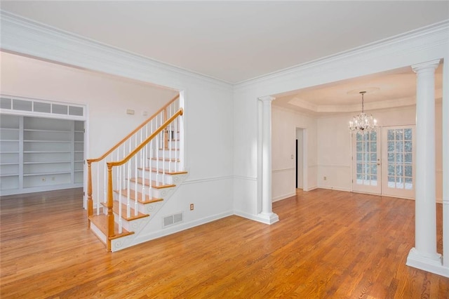 5010 Bonnie Way, Roswell, GA 30075 - stairs with ornate columns, wood finished floors, a chandelier, crown molding, and built in shelves