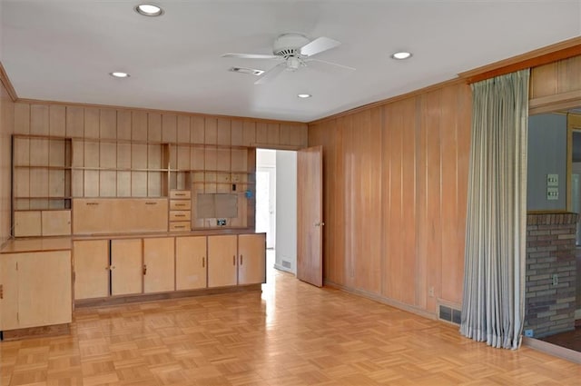 unfurnished room with recessed lighting, wood walls, visible vents, a ceiling fan, and ornamental molding