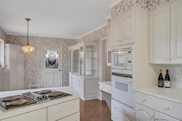 kitchen featuring crown molding, white appliances, decorative light fixtures, and wallpapered walls