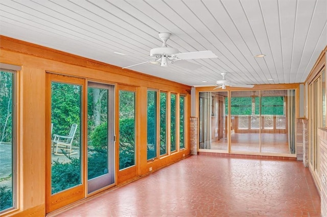 unfurnished sunroom featuring ceiling fan