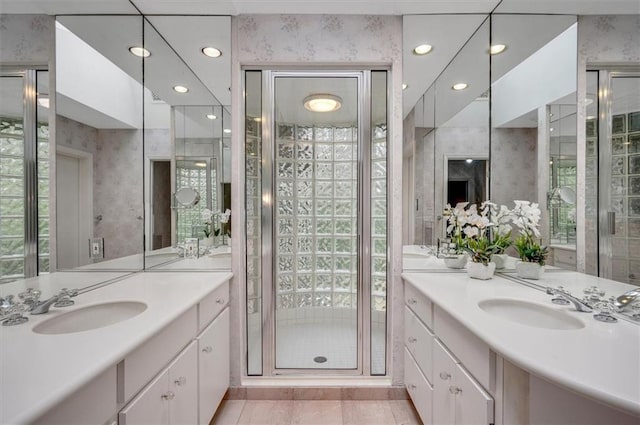 full bathroom with recessed lighting, two vanities, a sink, and wallpapered walls