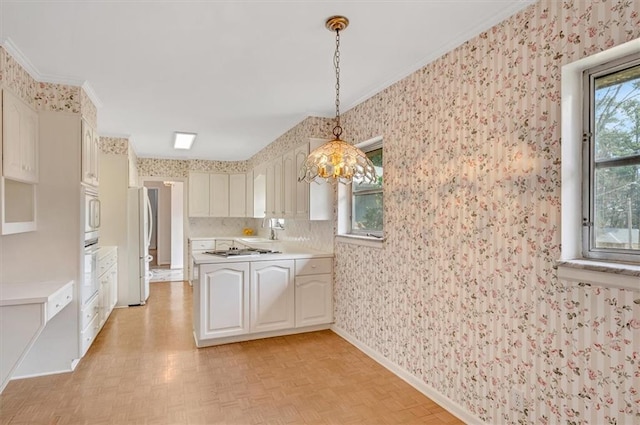 kitchen with a healthy amount of sunlight, wallpapered walls, and white appliances