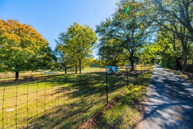 view of property's community featuring a rural view and a lawn