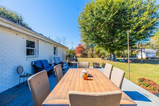 wooden terrace featuring a yard and outdoor lounge area