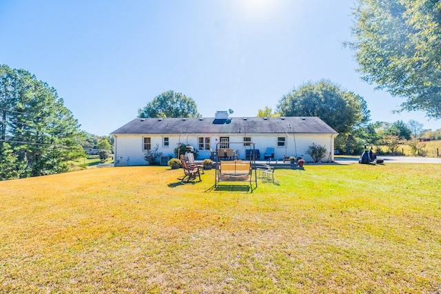 rear view of house featuring a lawn